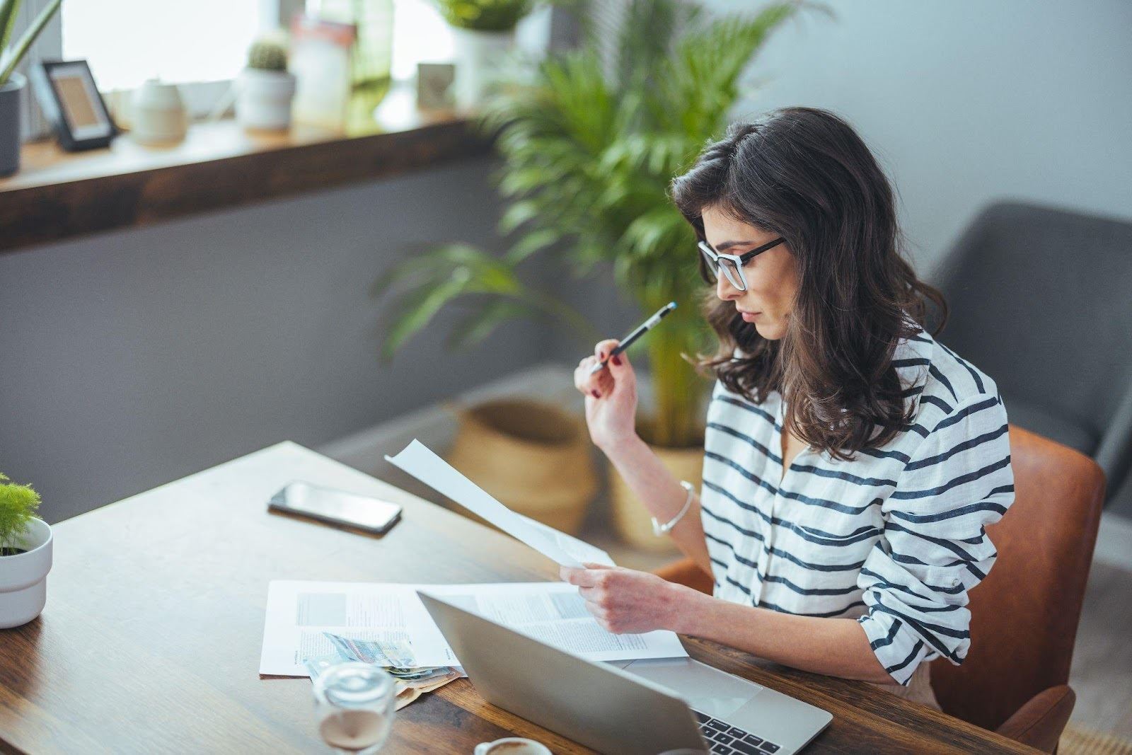 A woman working at a desk in a home office, focused on her tasks