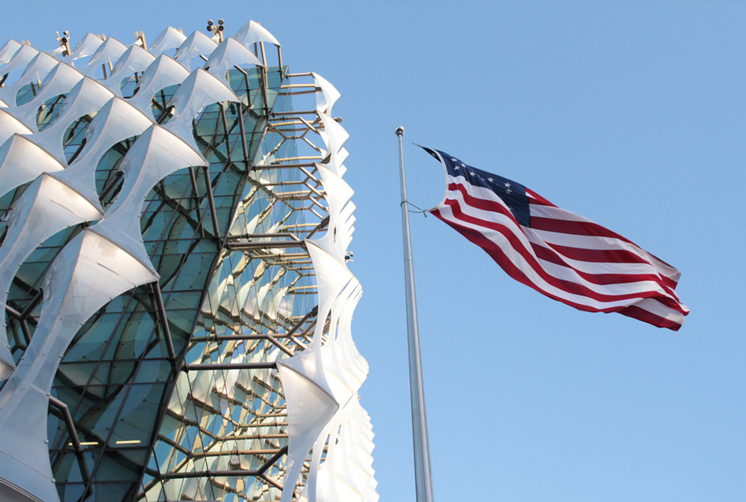 A US flag proudly flies in front of a building