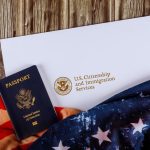 U.S. Citizenship and Immigration Services passport alongside an American flag, symbolizing the journey to U.S. citizenship.